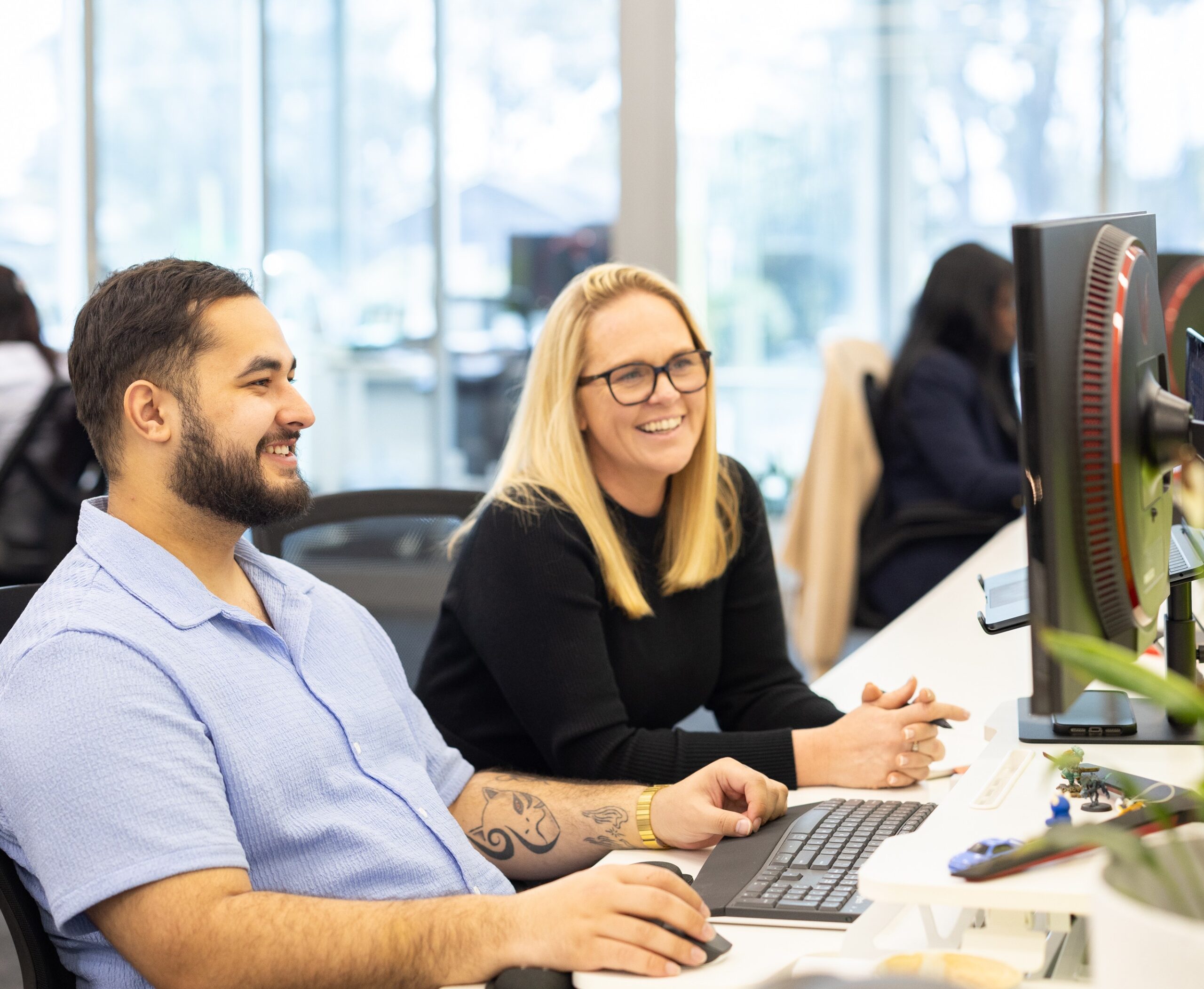 What's in it for you? Two IGNYT team members smiling while editing work, ensuring further success for you